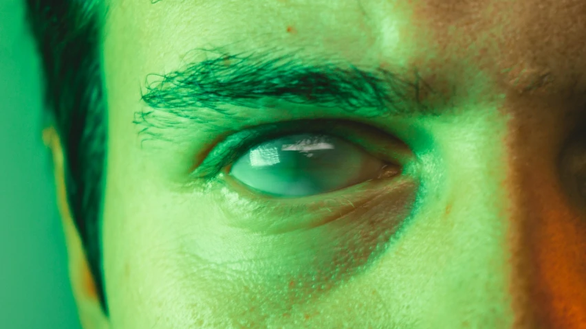 an eye close up is reflecting green and white