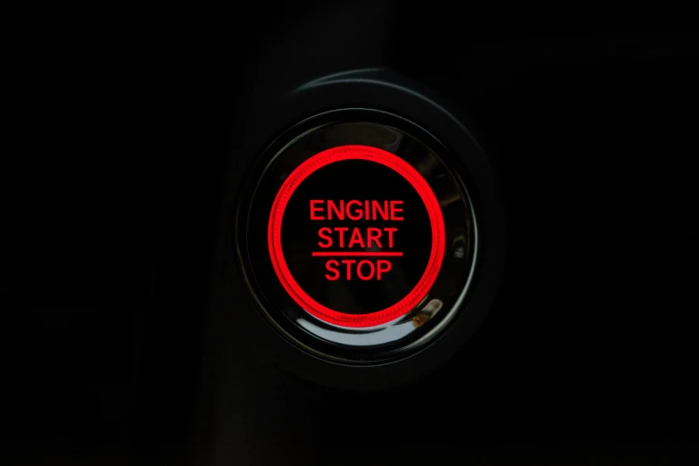 a sign reading engine start is on a dark surface