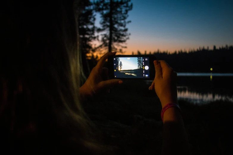 someone is taking pos of the sunset in their cell phone