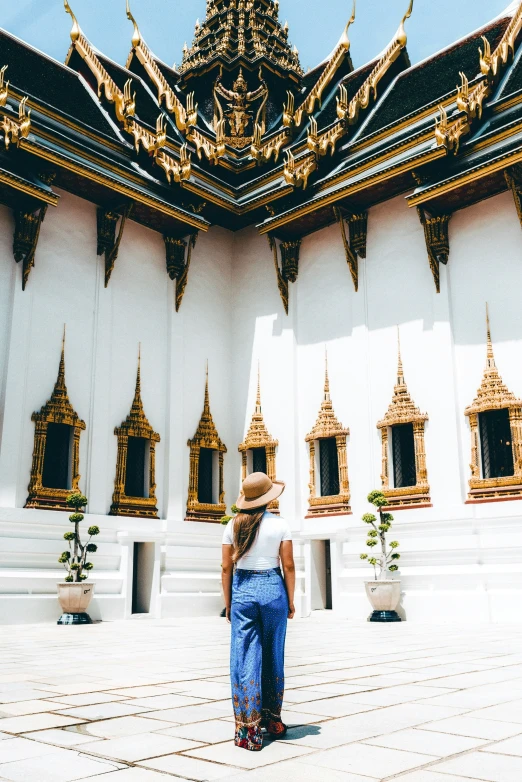 a person standing in front of a building with gold and white trim