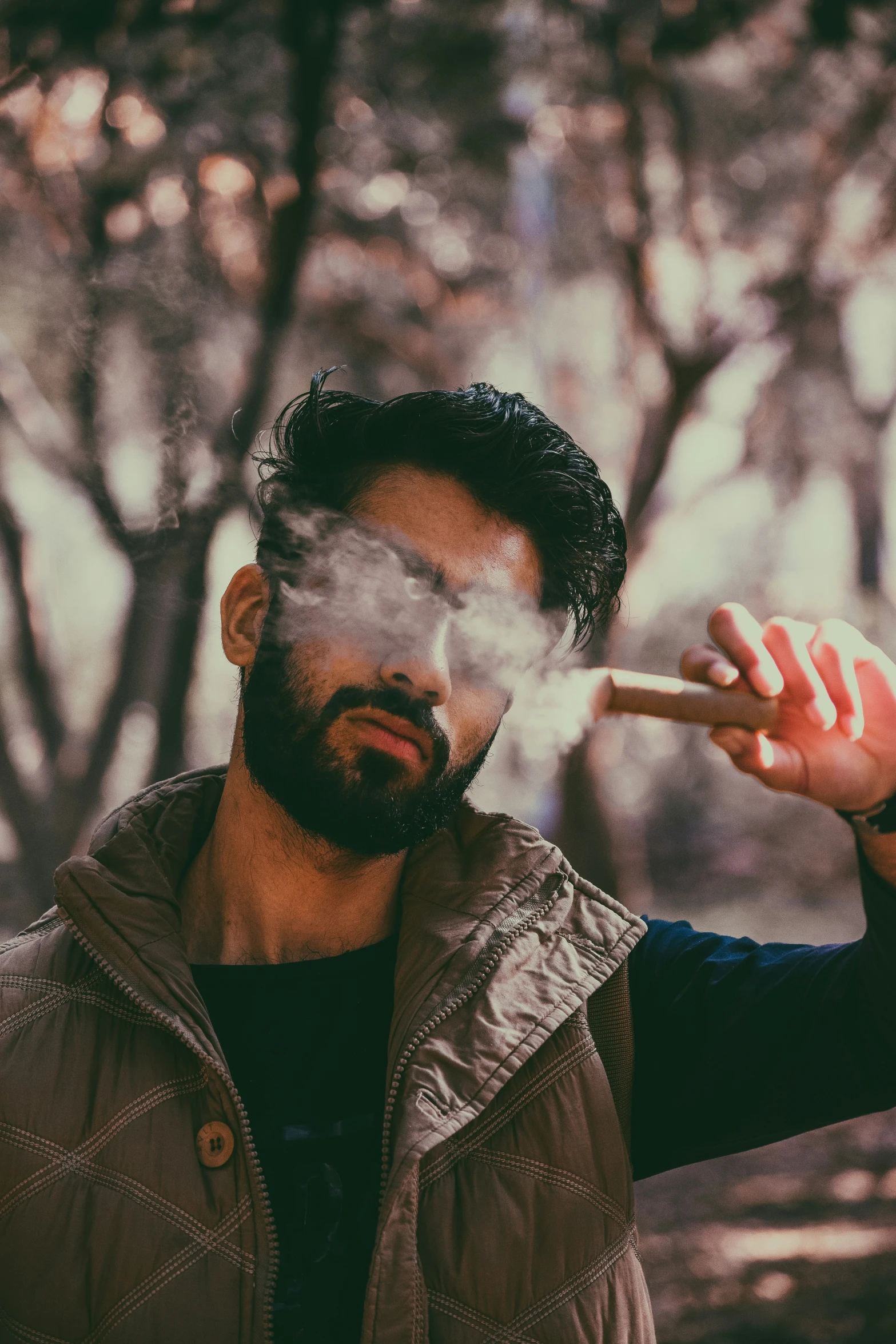 a man is in a forest smoking an electronic cigarette