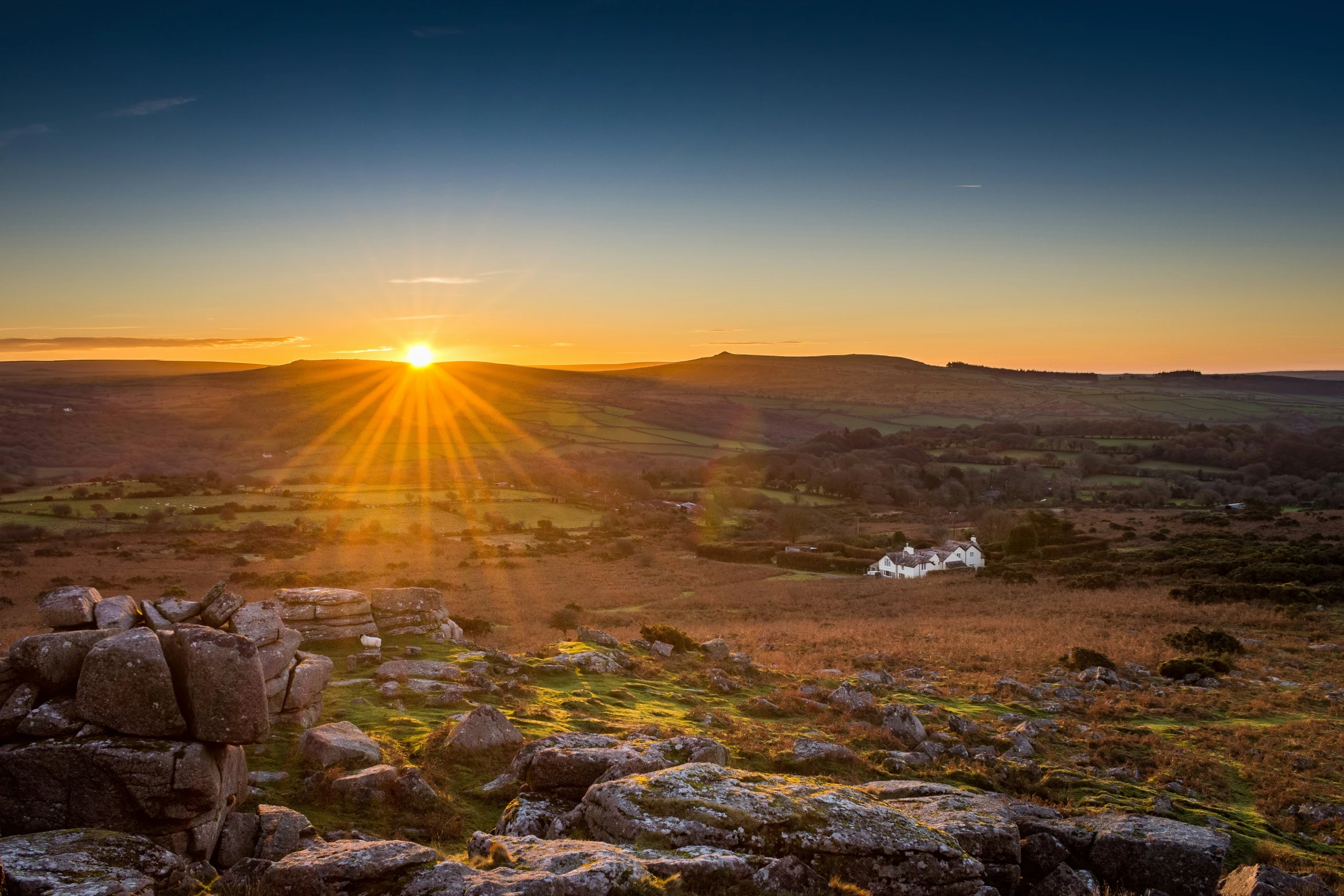 sunset on the horizon over rocky plains and hills