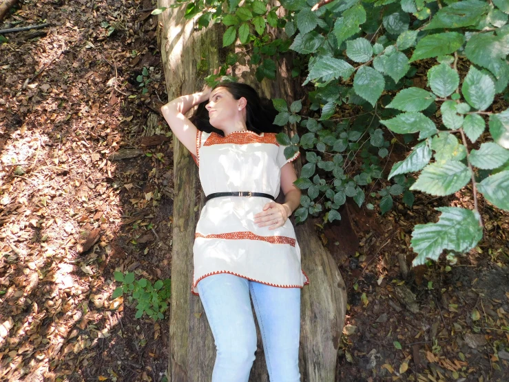 a woman who is laying down next to a tree