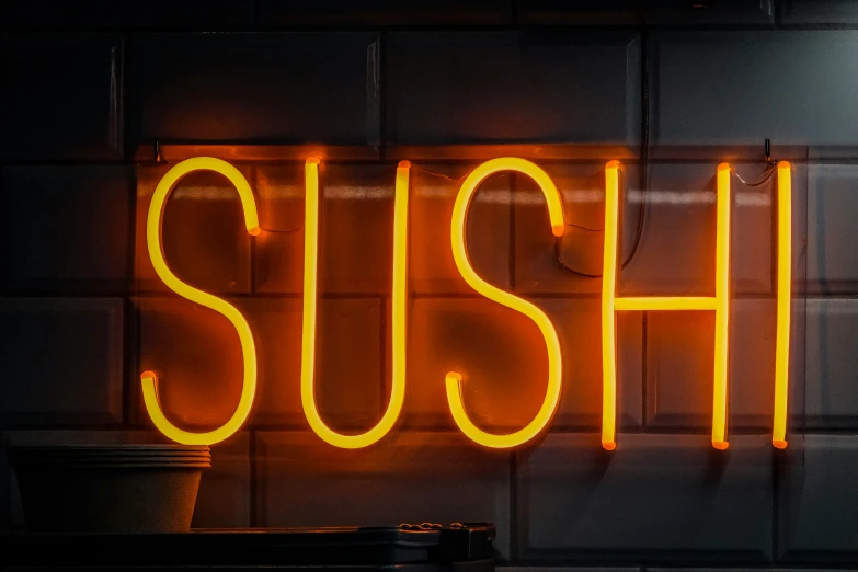 neon sign saying sushi on a brick wall