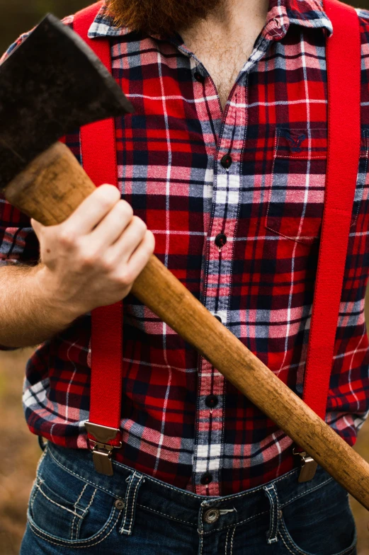 the bearded man holds an axel while he holds a stick