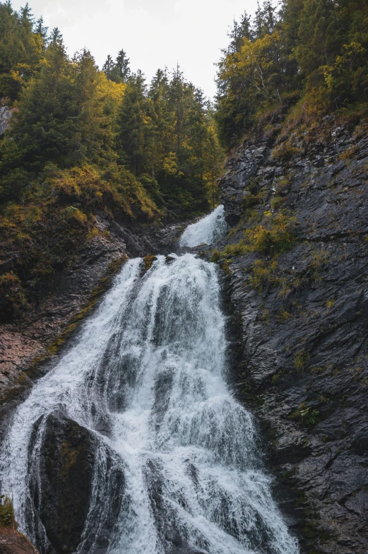 a waterfall with water running down it on the side of a mountain