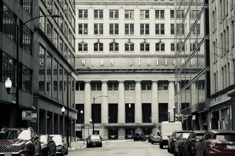 cars lined up outside a building with a staircase above