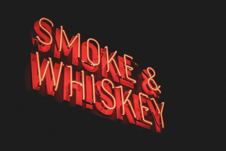 a red neon sign reading smoke & whiskey