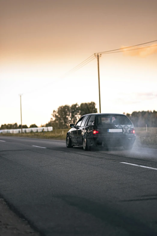 a car driving down the road with smoke coming out of it