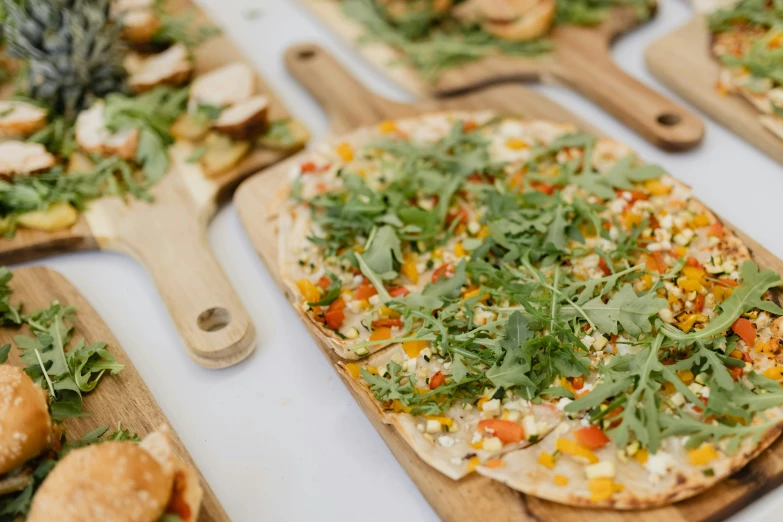 fresh vegetable flatbread pizzas on  boards ready to be baked