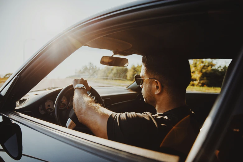 a man sitting in a car driving down the road