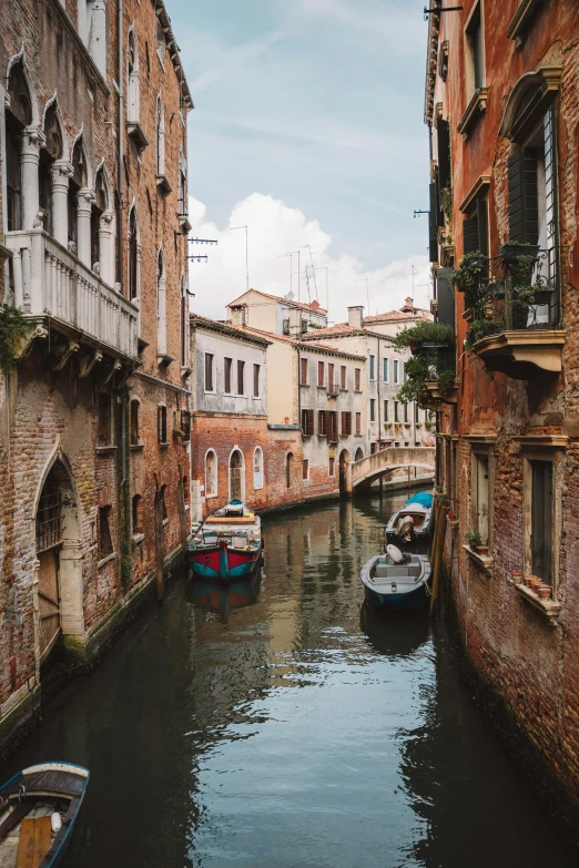 small boats are on the canals next to tall buildings