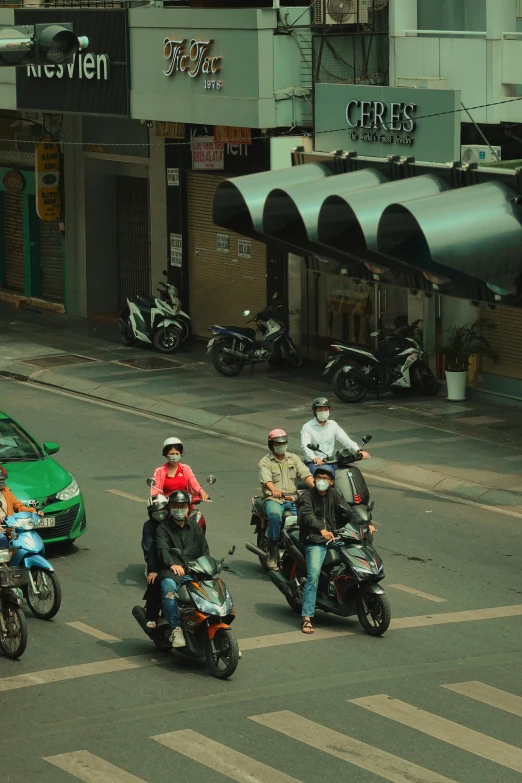 people on motorcycles and cars are passing by in traffic
