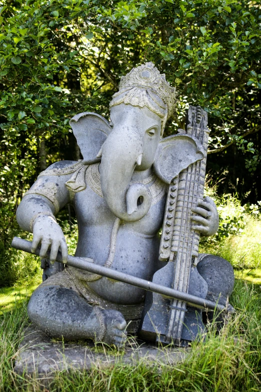 there is an elephant statue holding a musical instrument