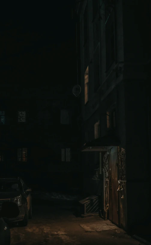 a couple of dark buildings at night, with the street light on