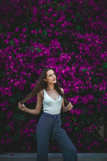 a girl posing with some flowers behind her
