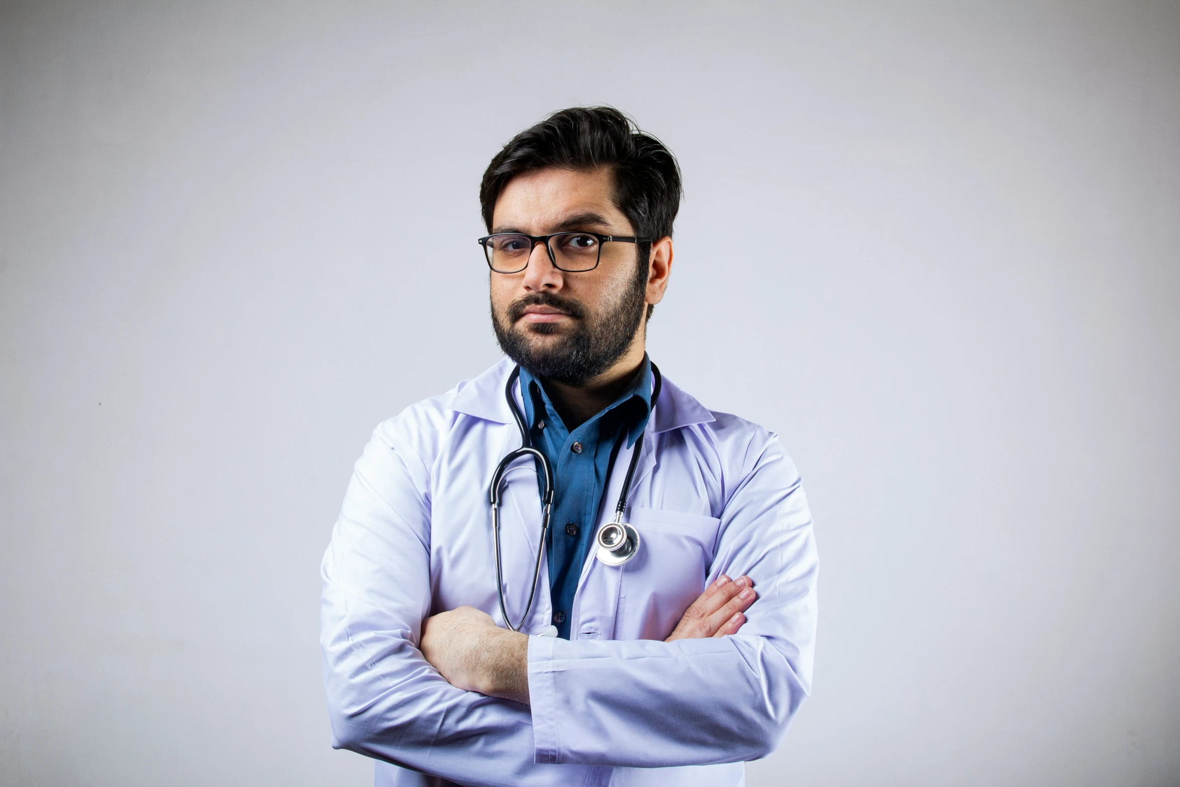 a man with his arms crossed wearing a doctor's coat