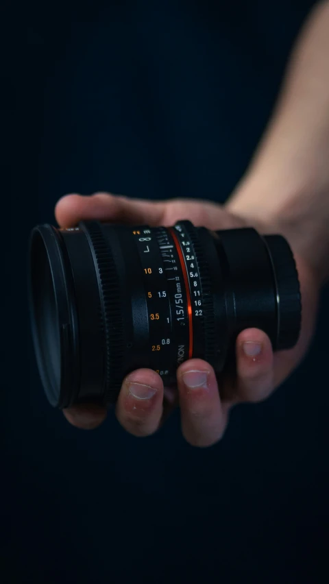 a person holding a camera lens in their hand