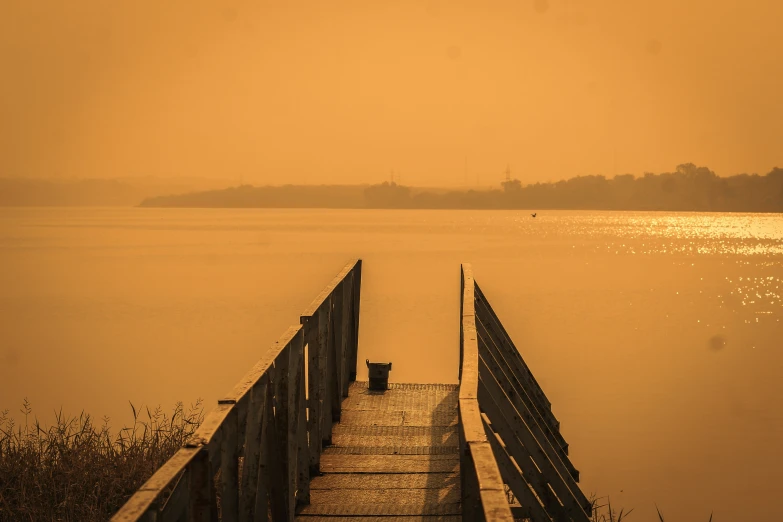 a pier sitting next to water in front of a lake