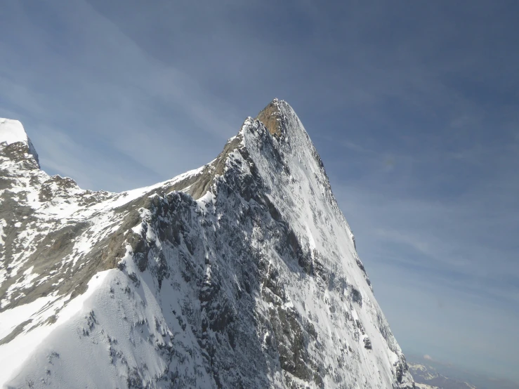 the view of a large, snow covered mountain with a sky background