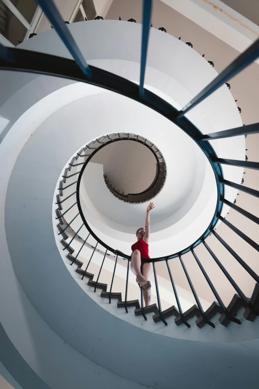 a woman standing in the middle of a spiral staircase