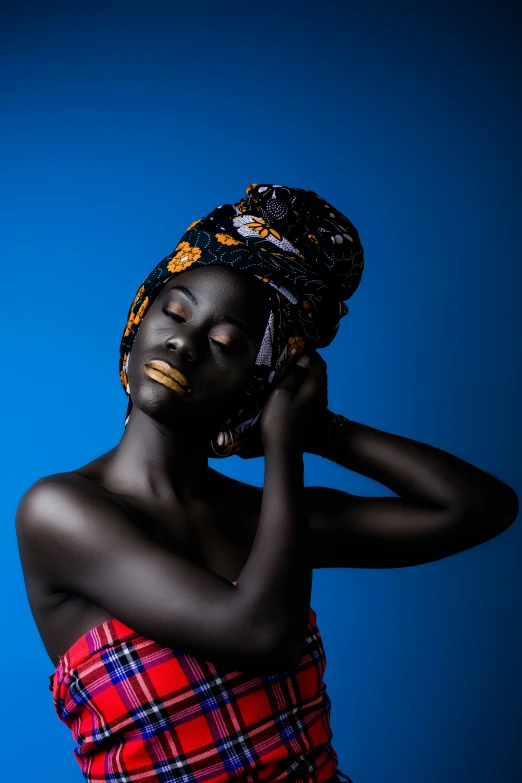 a woman wearing a hat standing up against a blue background