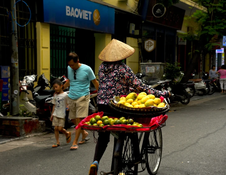 a woman hes a cart filled with fruit in the street