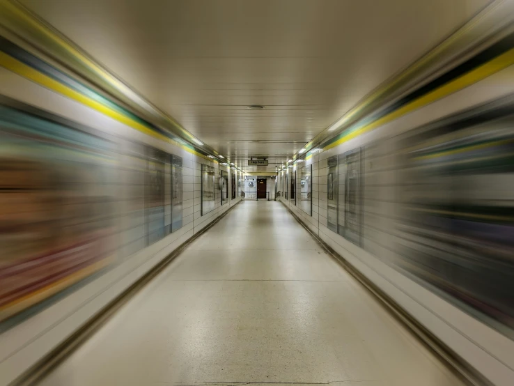 a blurry image of a corridor with a long wall