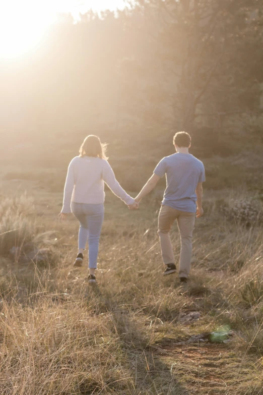 two people are holding hands on a field