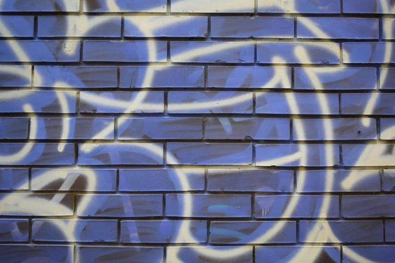 a wall with graffiti and blue bricks on it