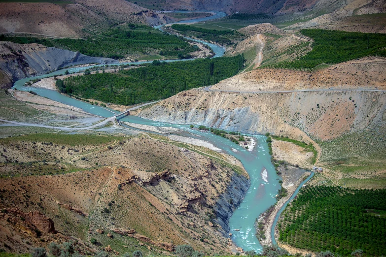 a stream runs between two mountains and passes into the valley below