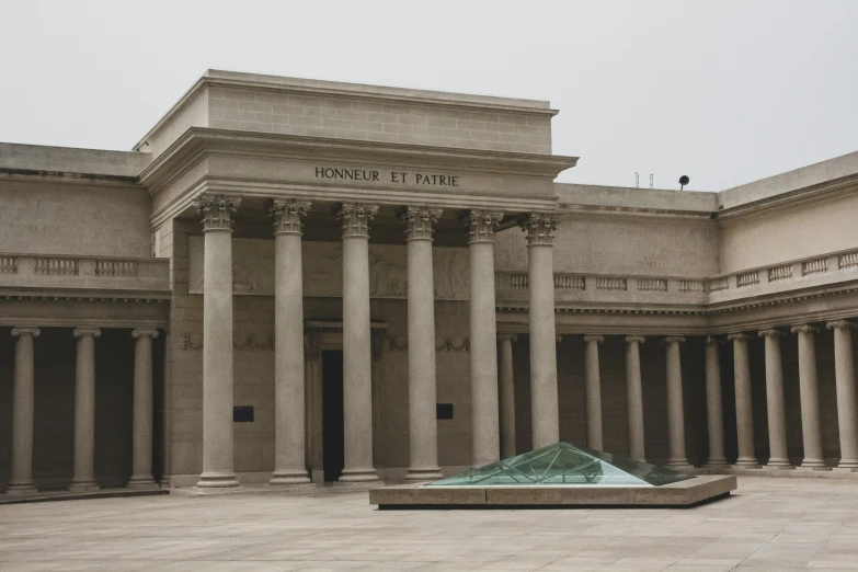 a row of columns sitting next to a green sculpture