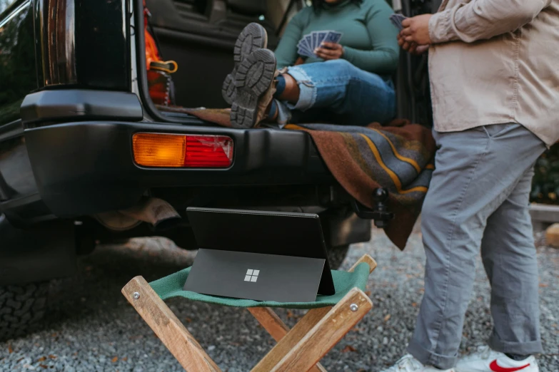 people standing around and talking in the back of an suv