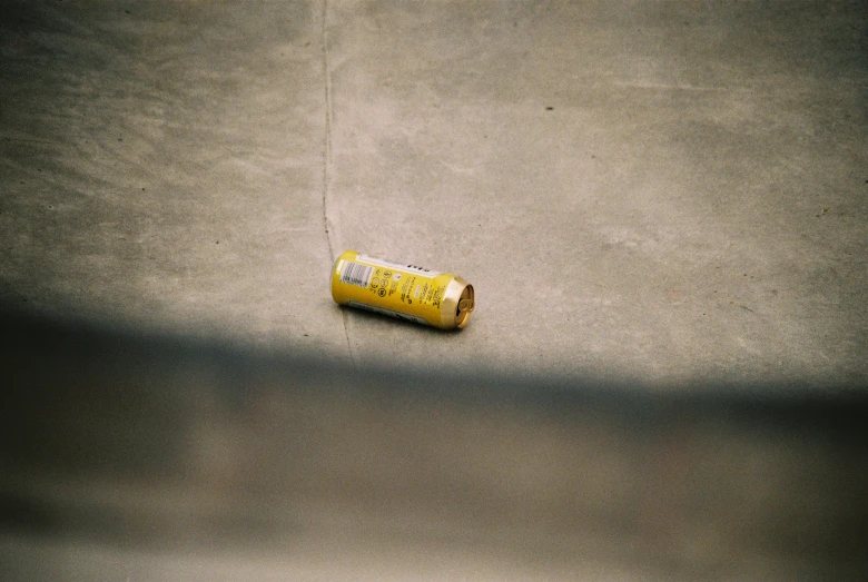 a lighter lying on the ground in the shade