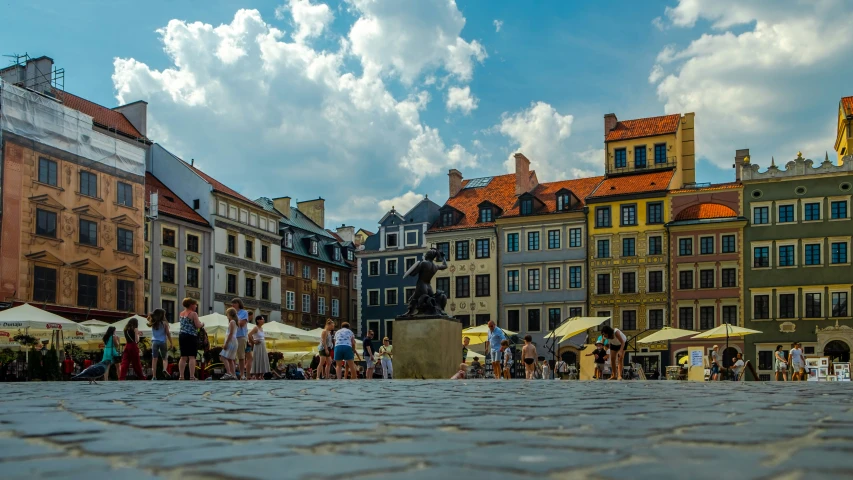 a group of people walking in front of a bunch of buildings