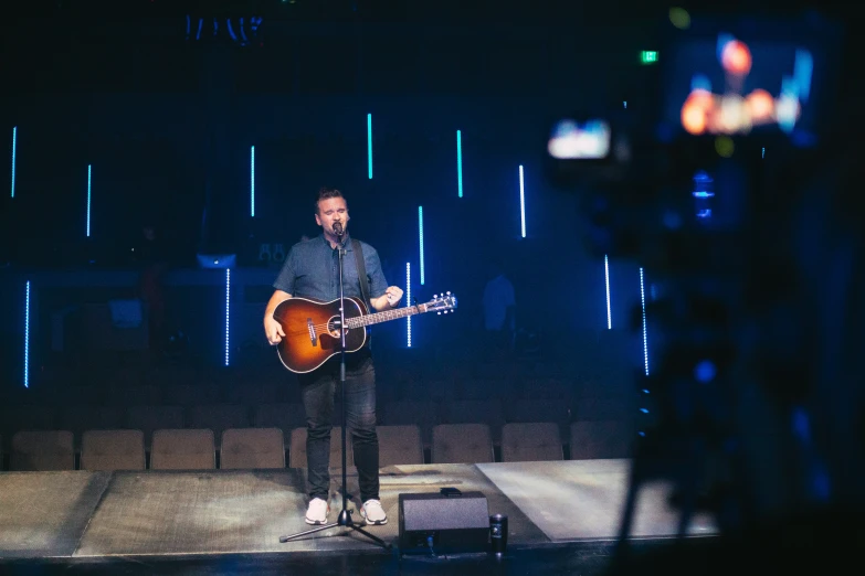 a person that is playing a guitar on stage