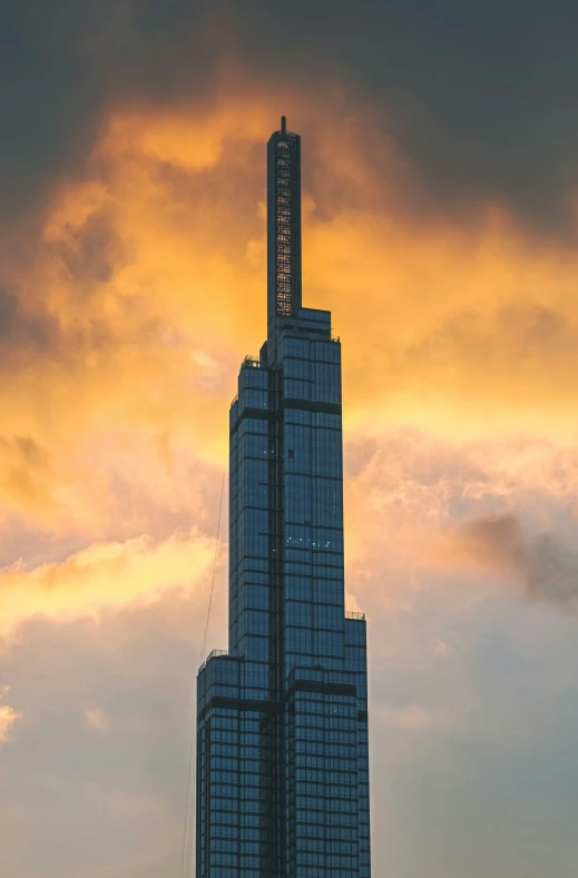 a tall building with a clock on top under clouds