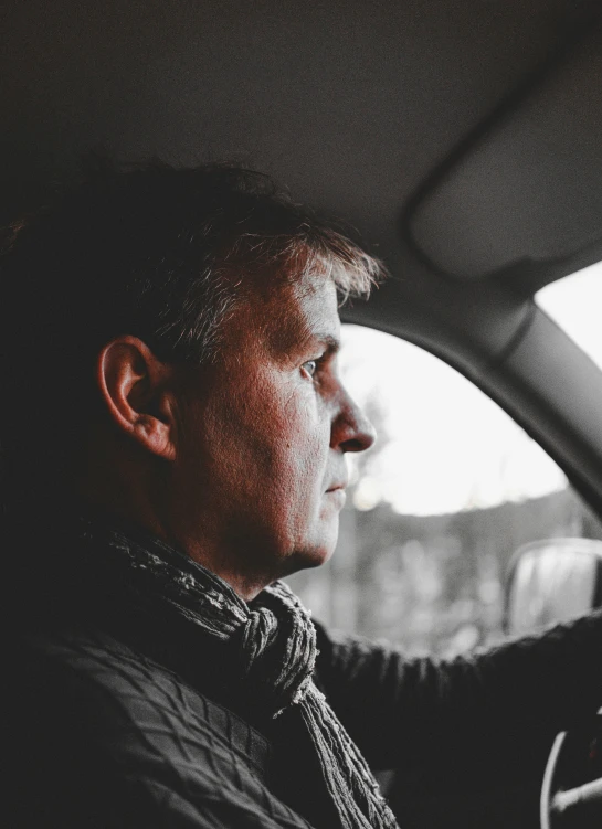 a man looking out the front window of a car