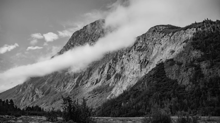 there is a mountain with clouds rolling in the air