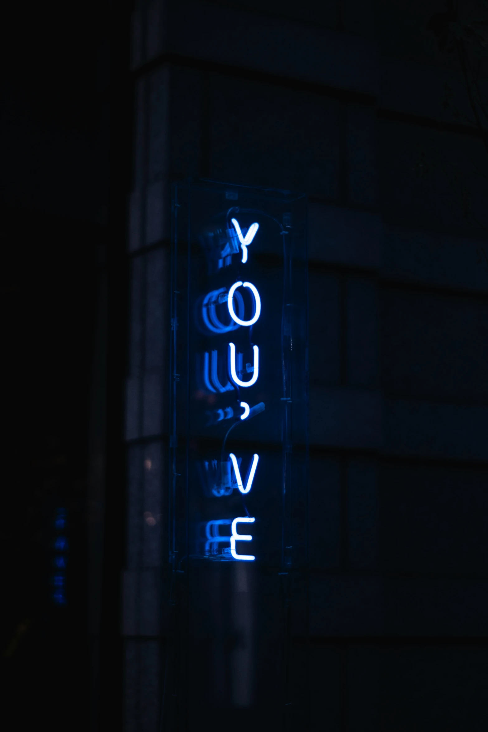 a blue light sign is lit up in the dark