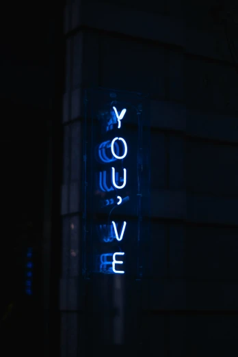 a blue light sign is lit up in the dark