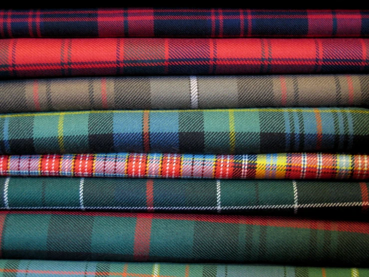 a pile of different plaid fabrics in a pile