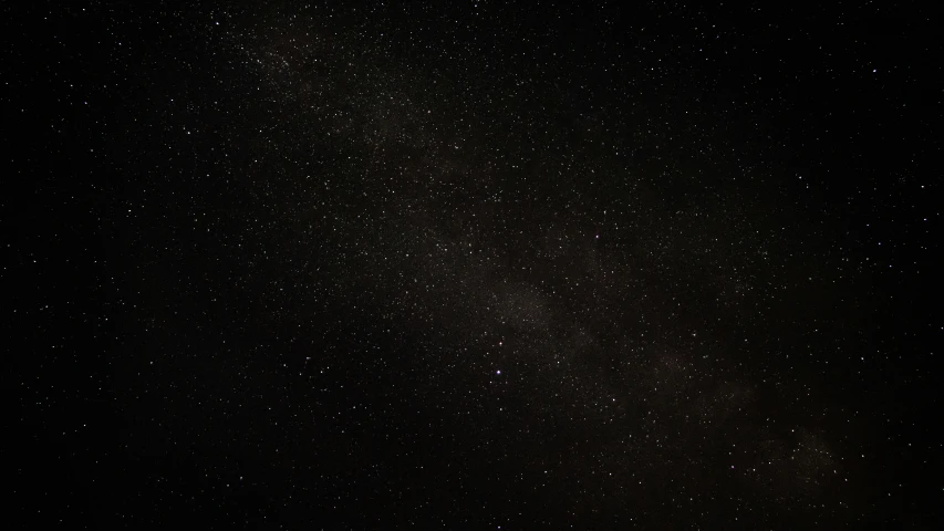 some stars are in the dark sky above a street sign