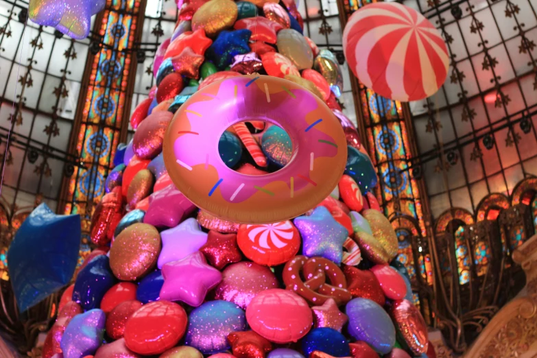 there is a very colorful decorated christmas tree in the mall