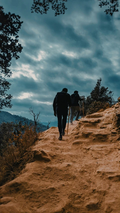 a man walks up the trail on a cloudy day