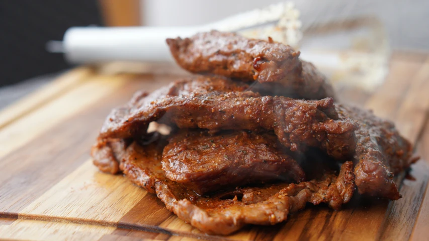 close up of meat being cooked on a  board