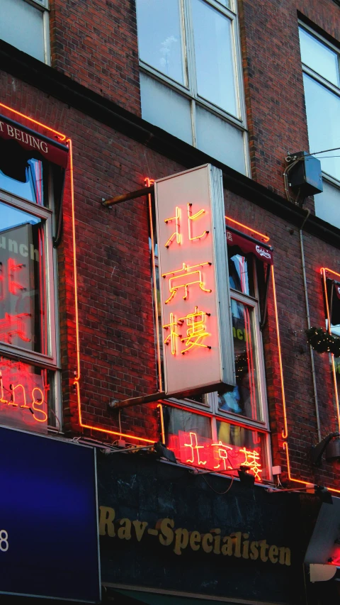 a building with windows and neon signs on the side