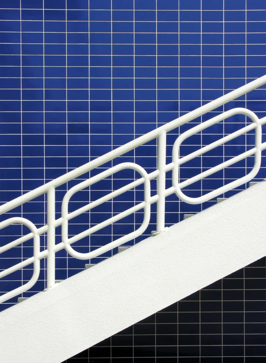 a white stairs with white railing and metal handrail