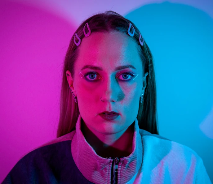 young woman wearing a necktie posing for a picture in a room that has multi - colored lighting