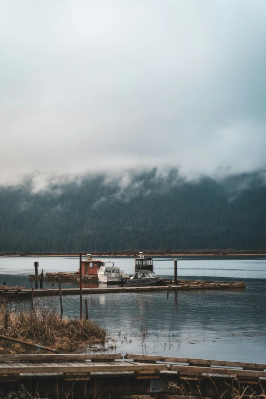 two boats sitting at the end of a dock